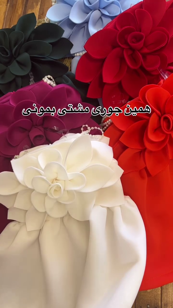 A collection of outfits, likely dresses or rompers for a young child, characterized by a very bold and voluminous large floral accent. - Image 2